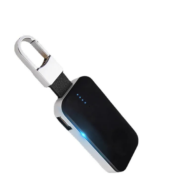 Black keychain-sized wireless power bank for Apple Watch showing front view and size relative to a keyring.