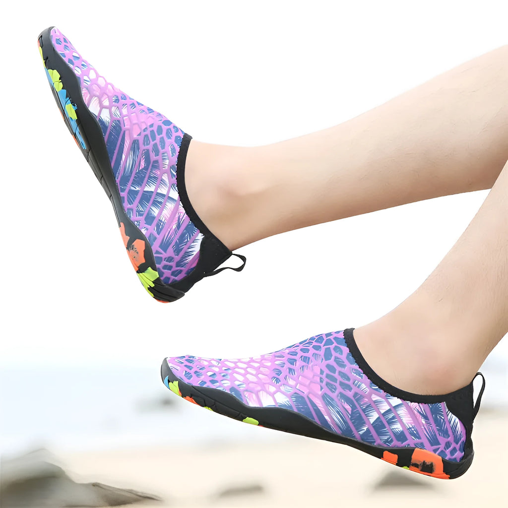 Pair of lycra and EVA water shoes in camouflage colour on a sandy beach