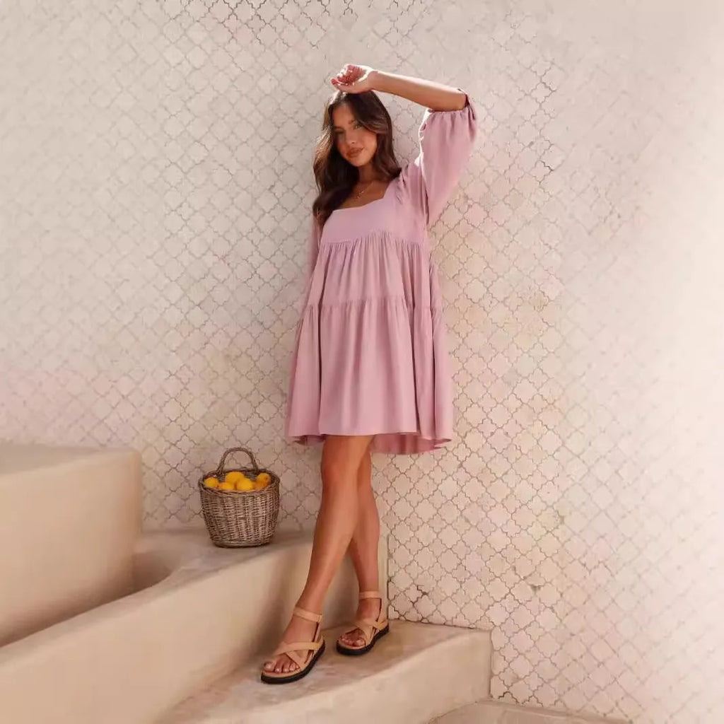 Orange backless children's dress with a square collar and puff sleeves on a mannequin.