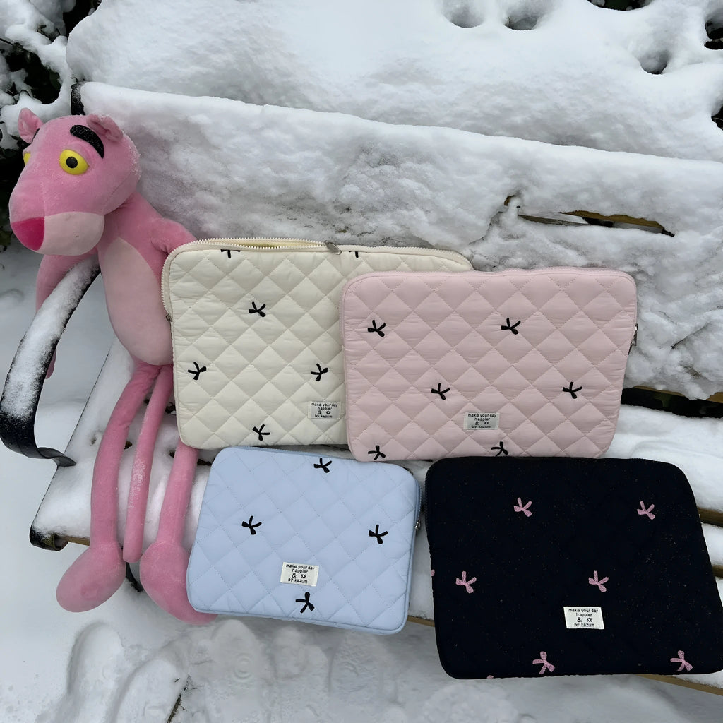 Nylon laptop storage bag with a rhombus-shaped embroidered bow on the front.