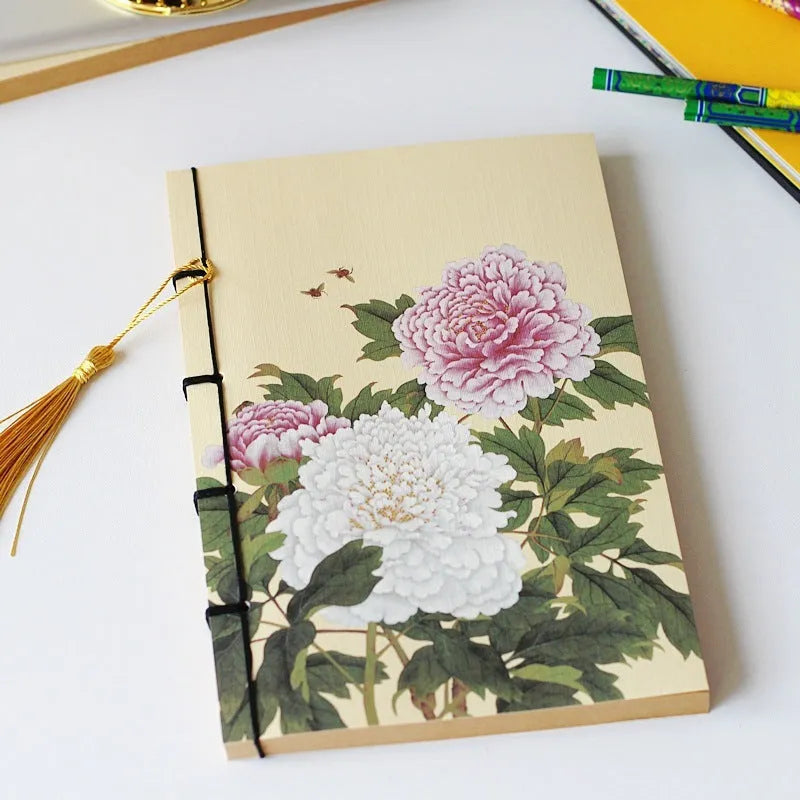 A5 antique wire-bound notebook with glossy embossed cover featuring a retro painting design, shown open.
