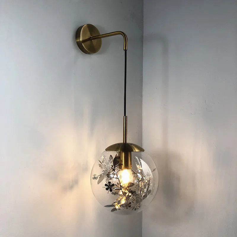 Modern glass wall lamp with metallic finish mounted beside bed for bedside lighting