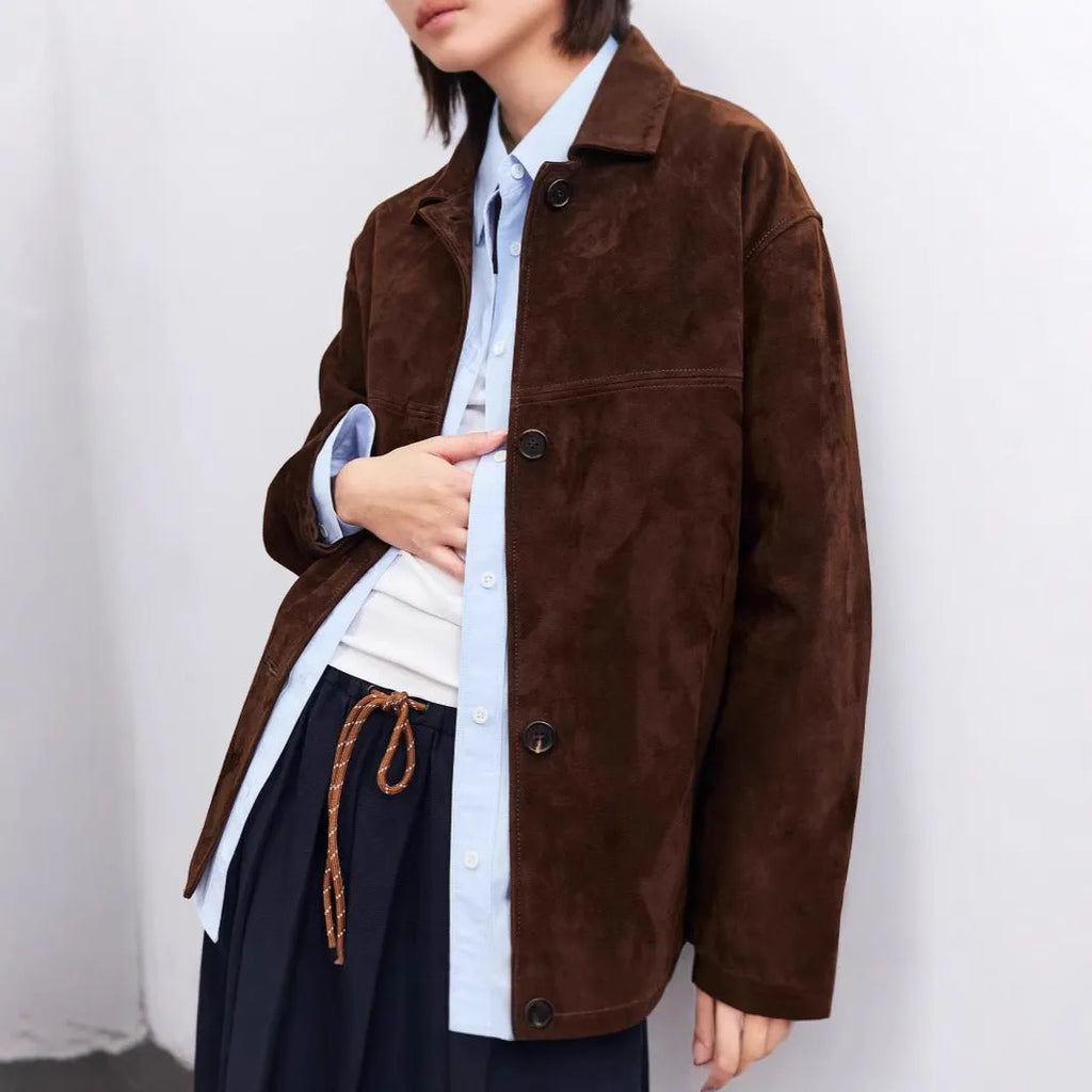 Yellow brown retro-style leather cashmere coat with Peter Pan collar and belt on a hanger.