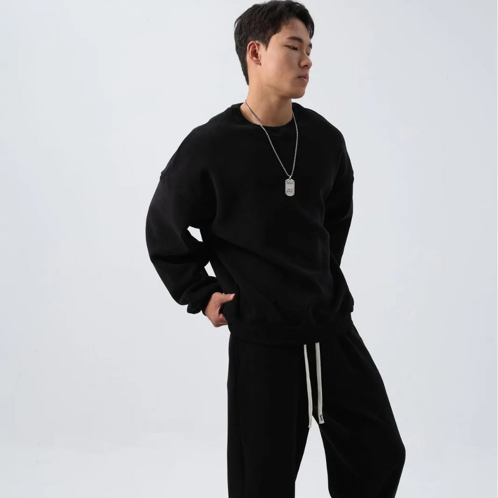 Men's black polar fleece sports suit with crew neck coat and matching trousers on a hanger.