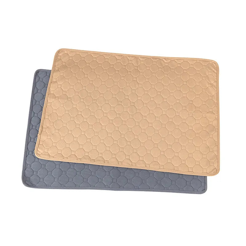 Set of two neutral-coloured washable dog pee pads on a wooden floor.