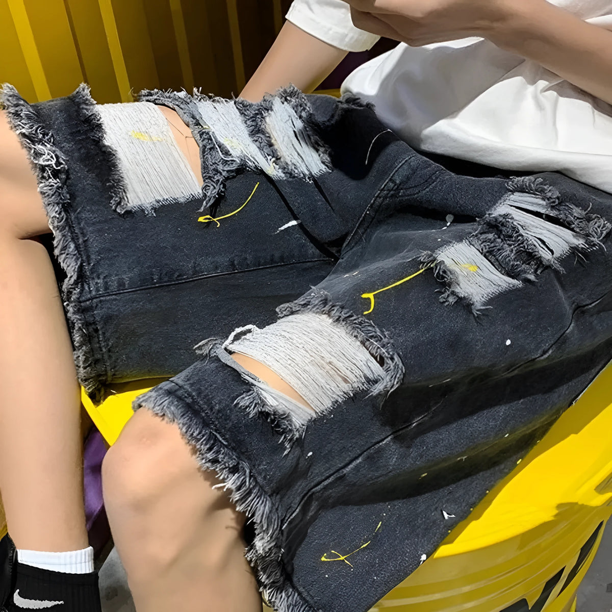 Men's water washed hole denim shorts in black and light blue colours showing loose street style fit