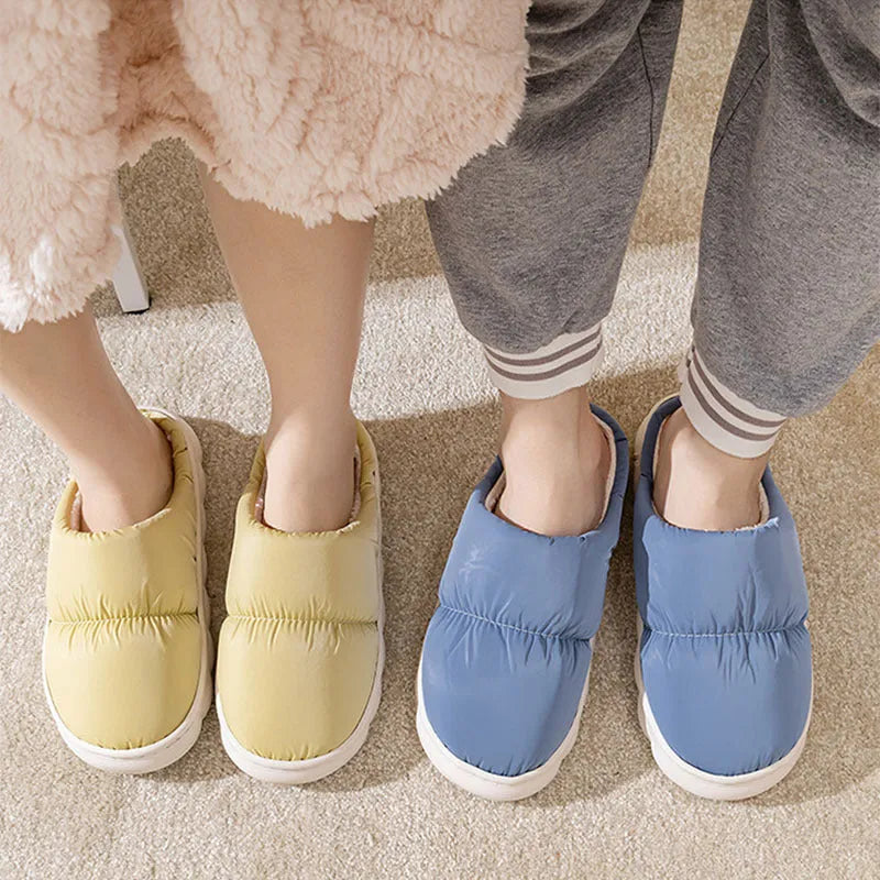 Blue down cotton slippers with artificial leather upper, thick rubber sole, and plush lining shown on a wooden floor.