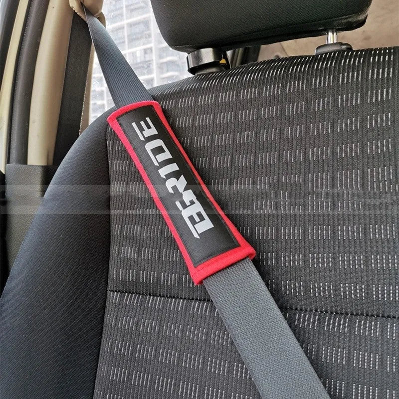Pair of black car seat belt shoulder pad sleeves with embroidery detail, showing dimensions.