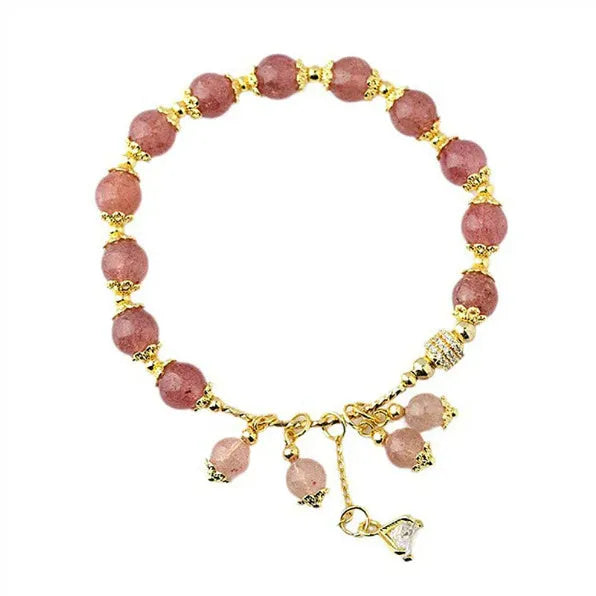 Close-up of a women's pink bracelet with a heart-shaped strawberry quartz crystal and small pearl accents on the band.
