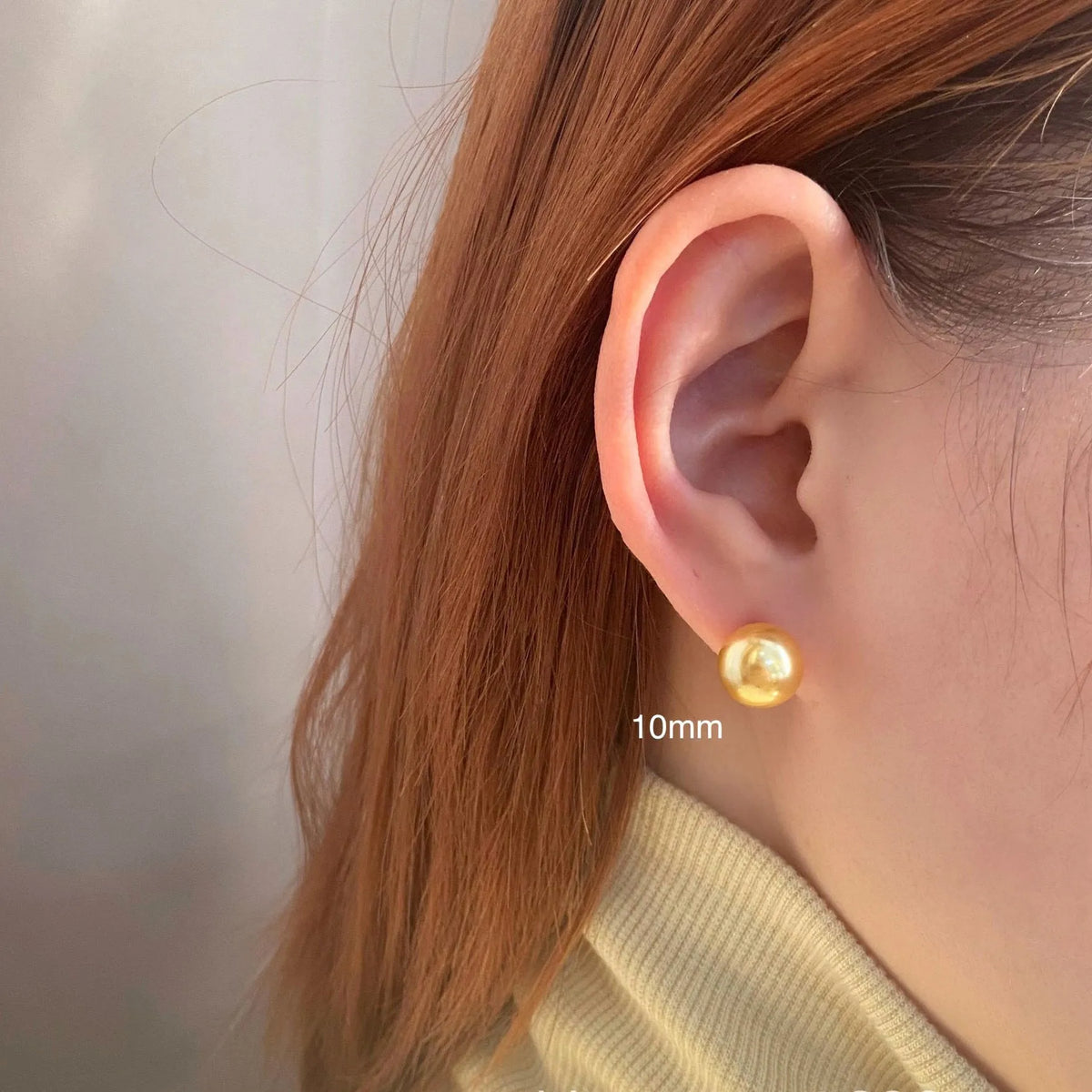 A pair of large geometric pearl stud earrings with an eight-point star detail on a silver setting.