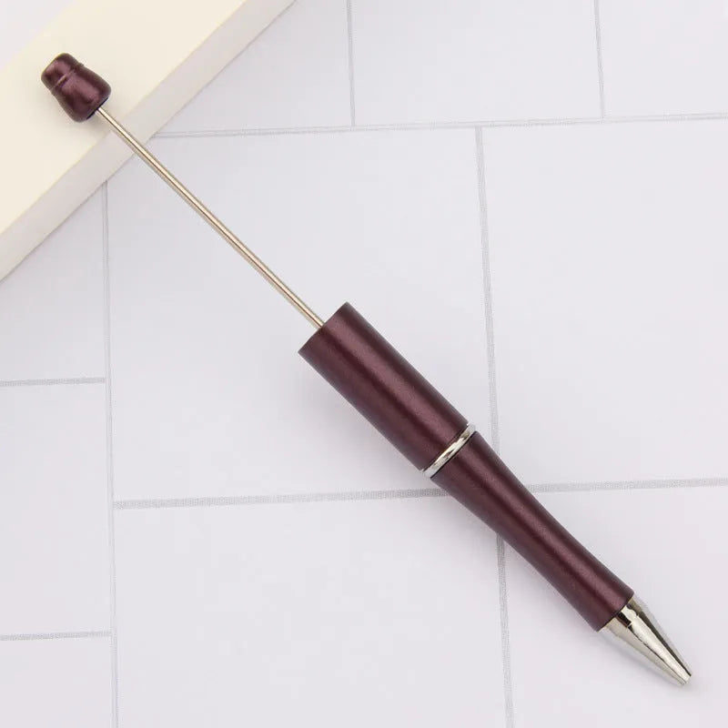 Ballpoint pen with colourful spinning plastic beads on barrel, shown in a gradient purple finish.