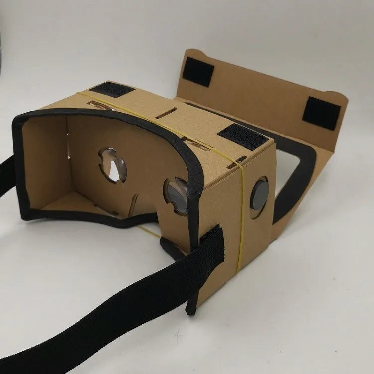 Pink and white foldable cardboard VR glasses headset for smartphones, showing 3D lenses and rubber head strap.