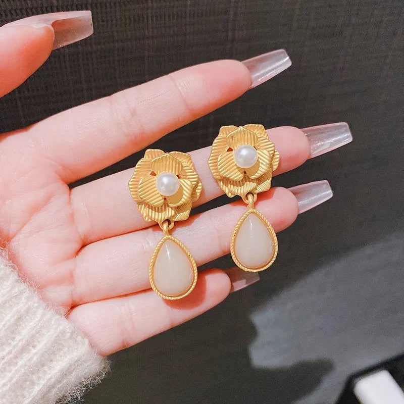 Gold floral stud earrings with rose pearl design, ice flower details, and a central opal stone.