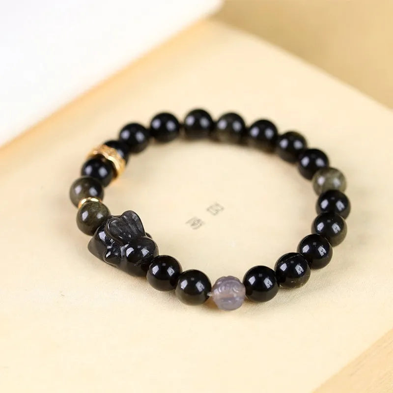 Handmade grey agate and silver lying rabbit charm bracelet on wrist, showing 10mm bead size option.