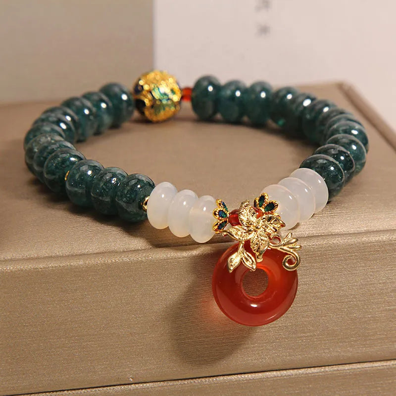 Blue water jade and red agate stone bracelet with peace buckle closure on crystal band