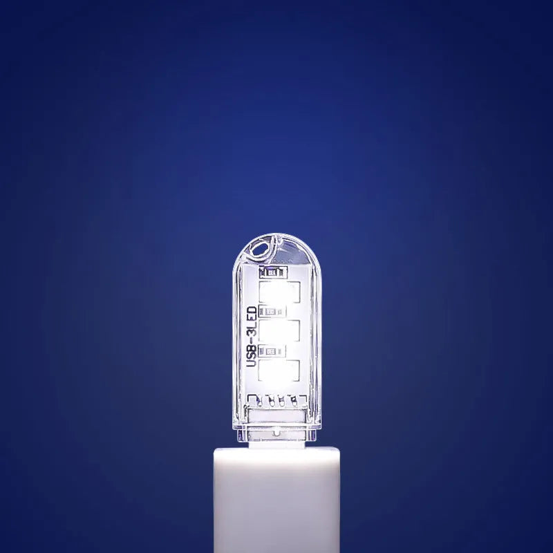 Small white LED night light showing warm and cool light options with USB charging port