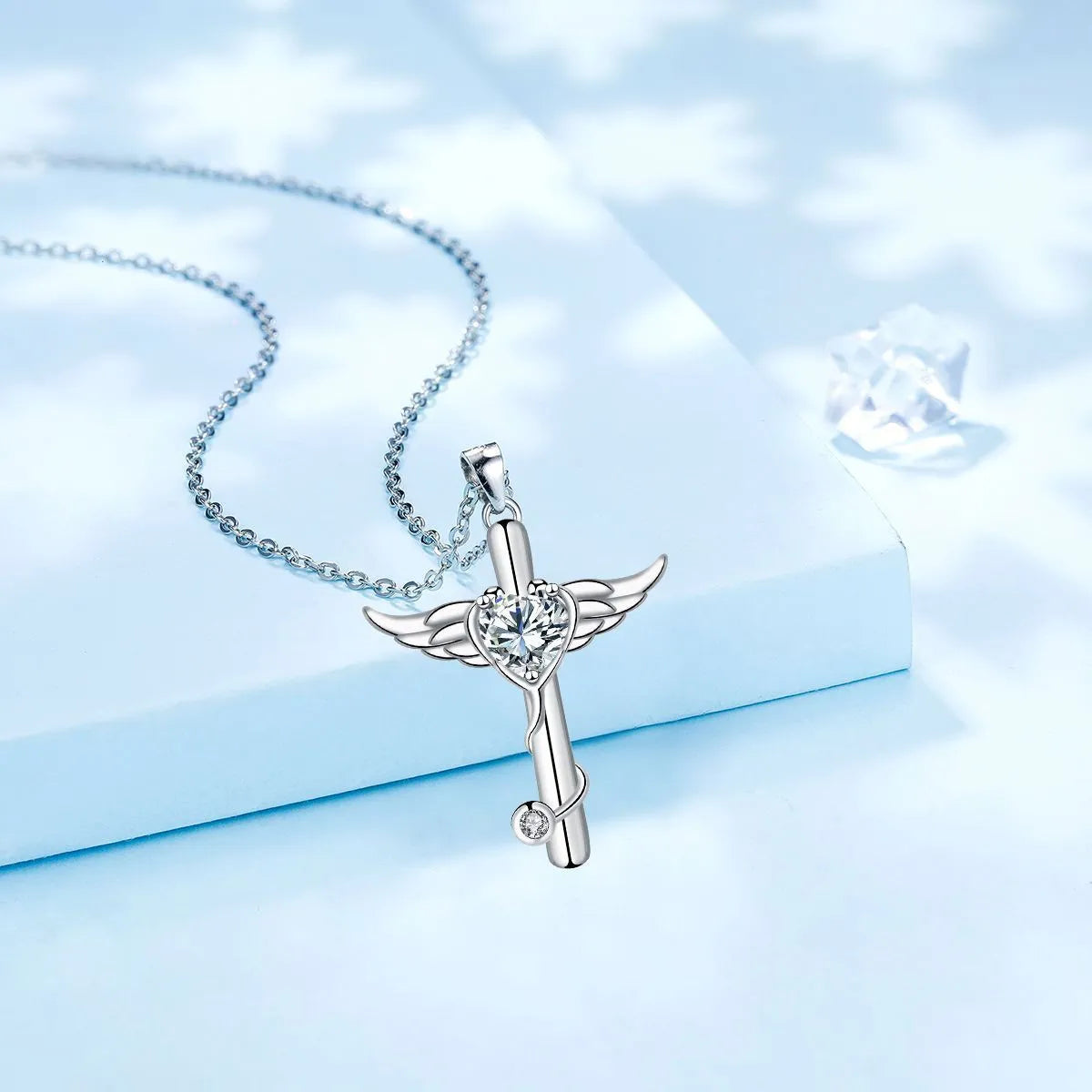 Close-up of a cross and angel wings charm on an adjustable stethoscope chain necklace.