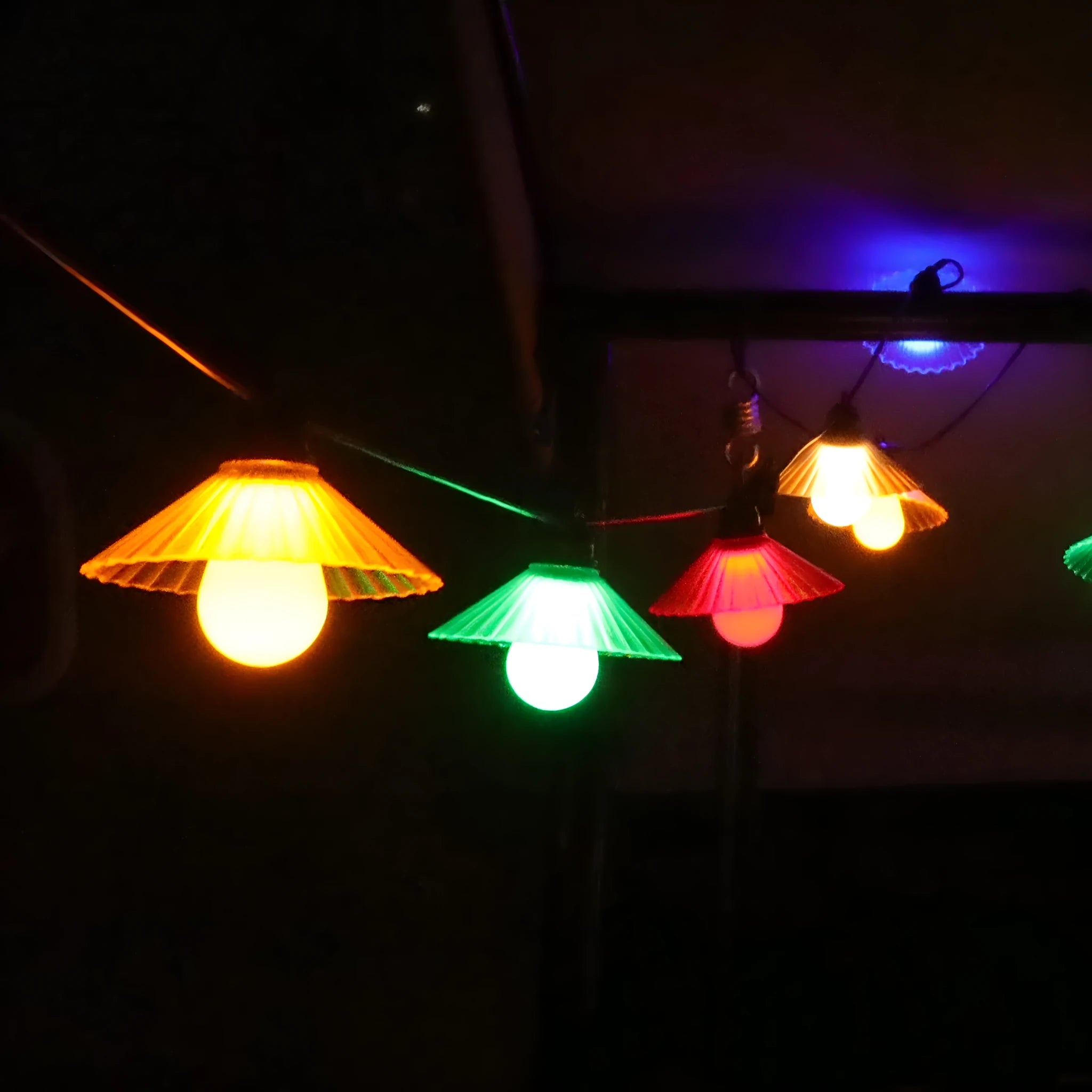 Outdoor flower-shaped LED string lights with IP65 rating hung in a garden setting.
