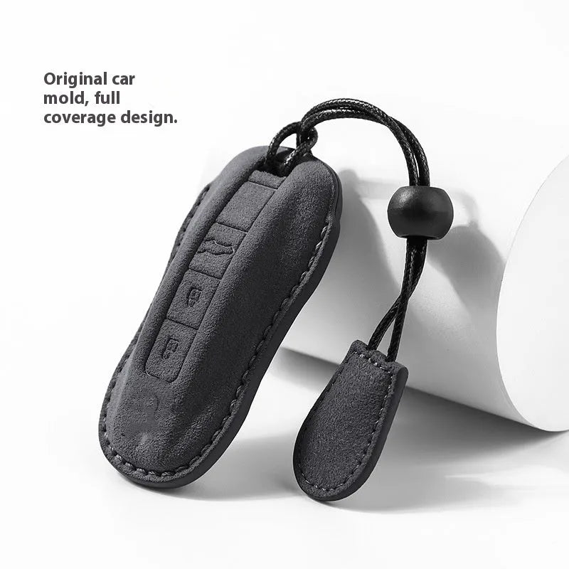 Suede car key cover in cement grey, dark green, light grey, and orange colour options