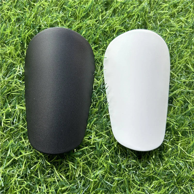 Extra small mini football shin guards in black and white colours showing 8x5cm plastic construction