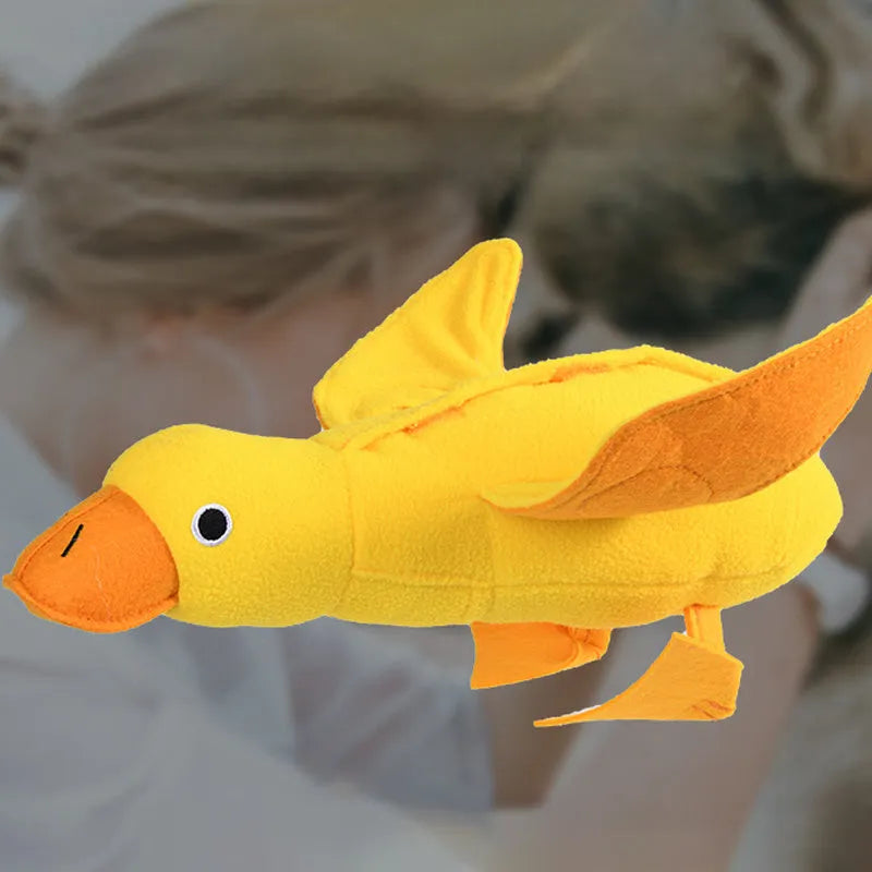 Yellow plush teddy dog toy with attached duck doll and food leak compartments for pet training