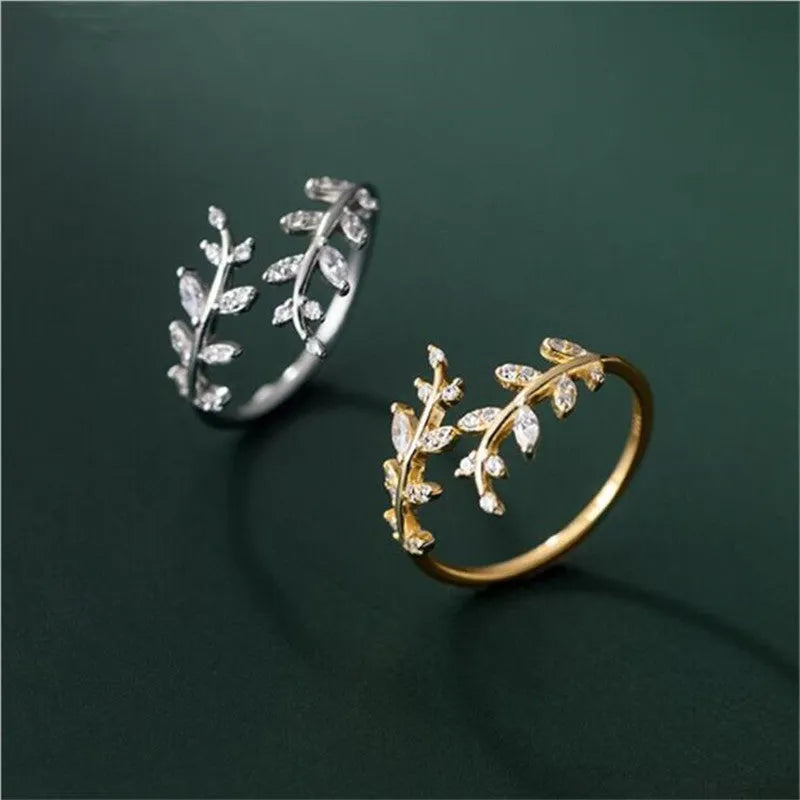 Close-up of a women's leaf-shaped branch fashion ring in a silver or gold electroplated finish on a copper base.