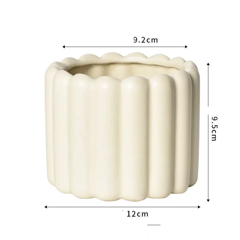 Roman column matte yellow ceramic flower pot on a surface.