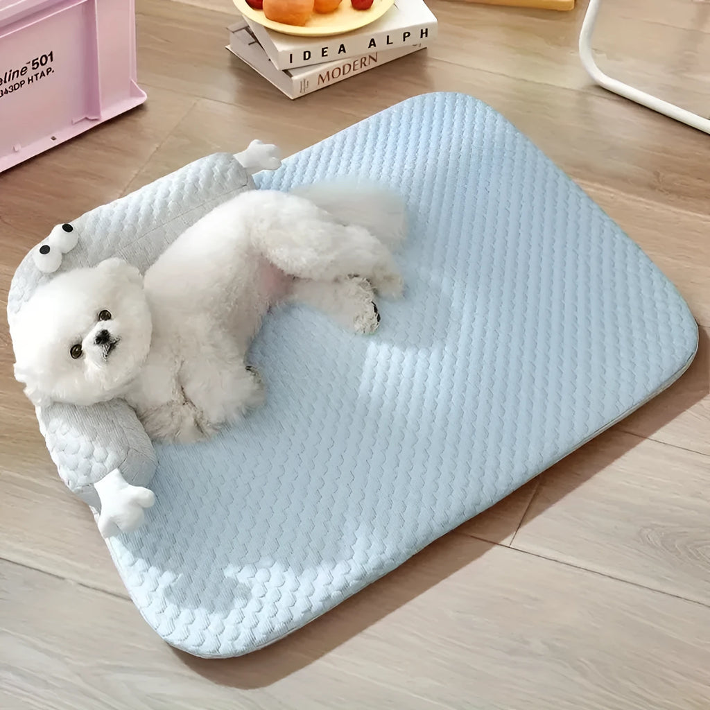 Blue pet bed cushion with big-eyed monster design for dogs and cats on a wooden floor.
