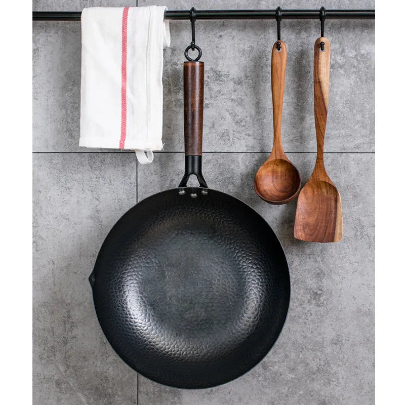 Traditional black iron wok with wooden handle measuring 32cm in diameter