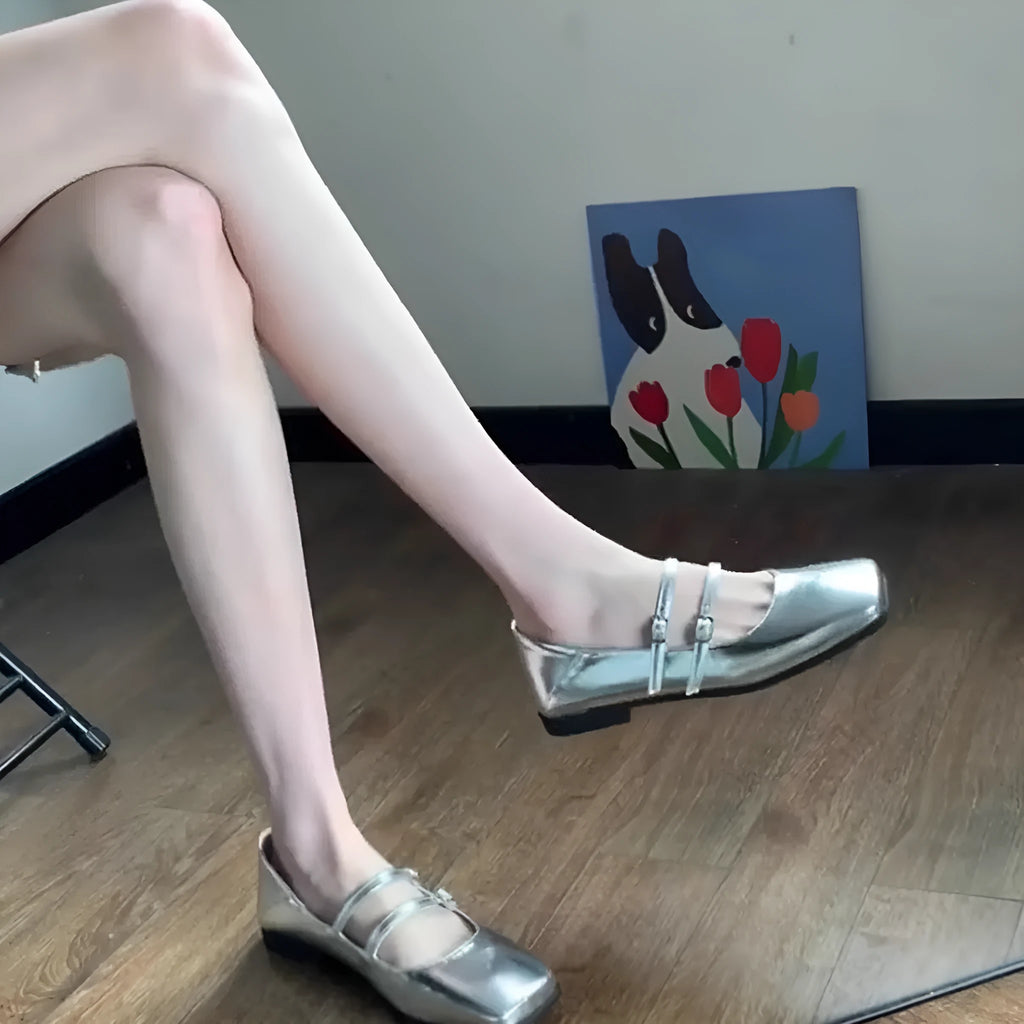 Silver women's leather ballet flats with a cross buckle strap and round toe.