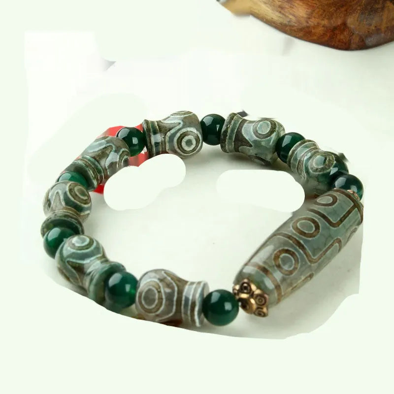 Distressed agate bracelet with traditional Tibetan dzi beads including three-eye and Nine Eyes designs.