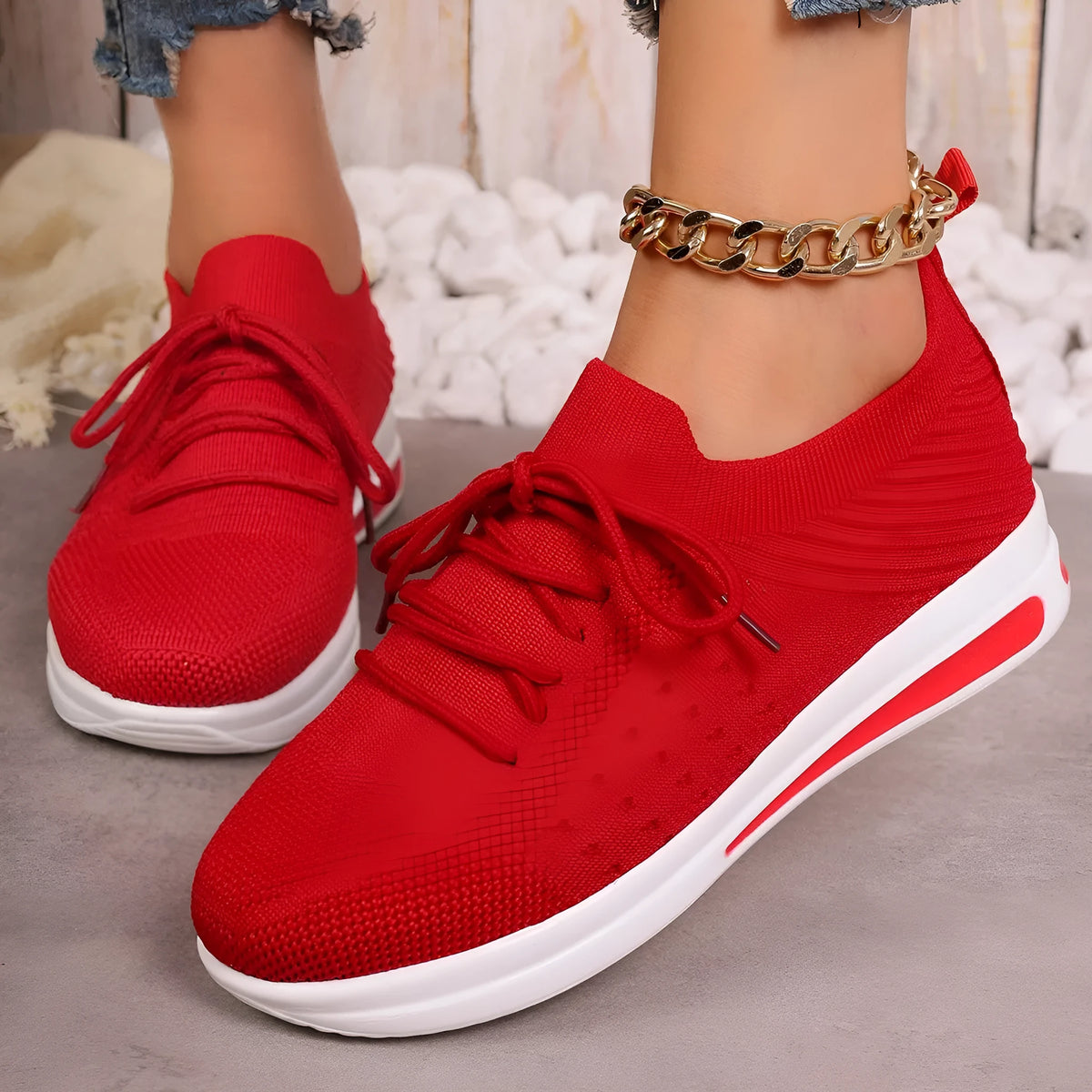 Women's low-top fly-knit style sneakers in black, blue, and red colours with round toe and lace-up front.