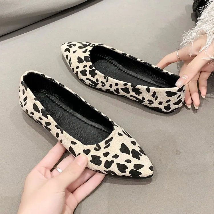 Women's leopard print flat pointed toe pumps with low heel on beige background