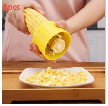 Yellow manual corn grinder thresher tool with corn-shaped design on a kitchen counter.