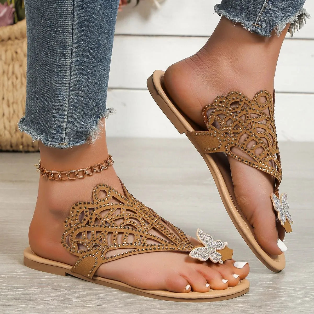 Women's black slip-on sandals with rhinestone detail and a flip-toe design on a flat rubber sole.