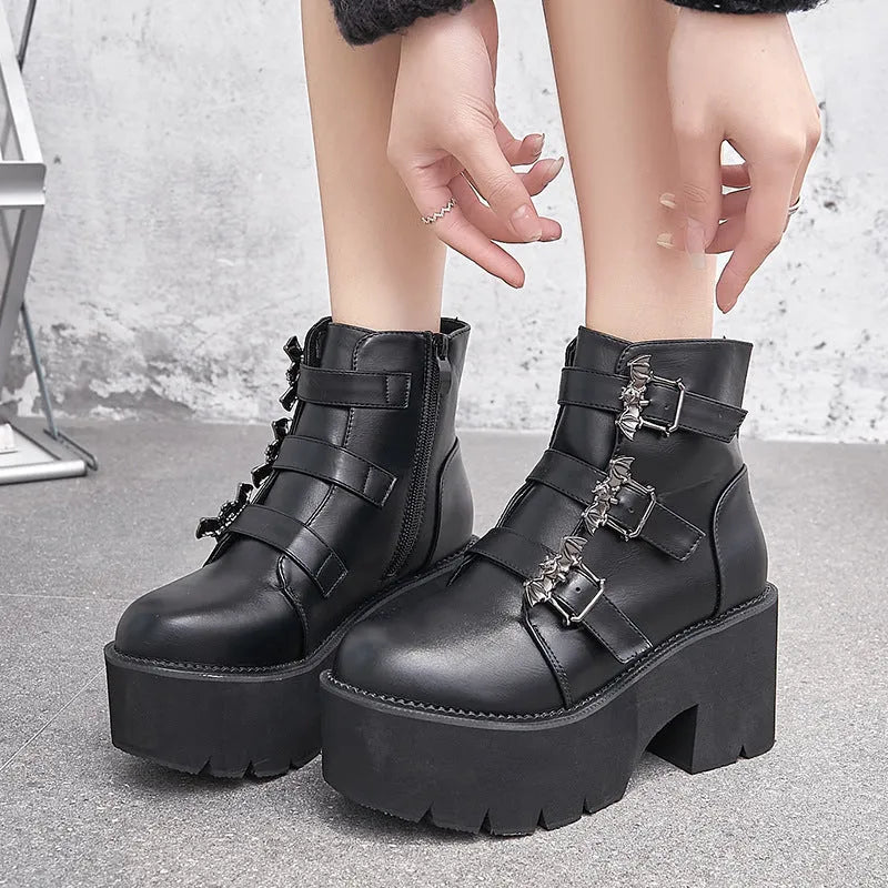 Black women's punk style short boots with bat buckle, thick heel, and side zipper.