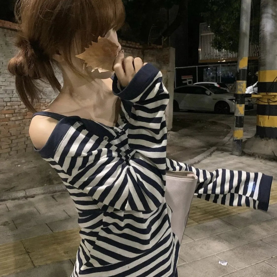 Dark blue oversized women's long-sleeved t-shirt with stripes and embroidery on a hanger.
