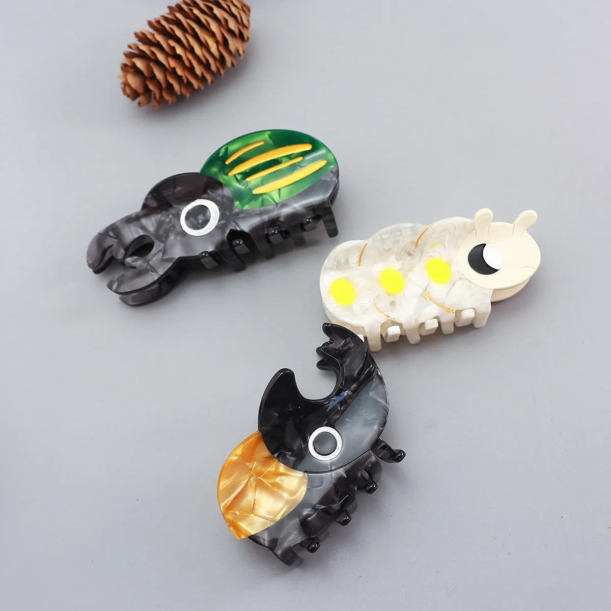 Handmade cellulose acetate beetle grip accessory in green, orange or white insect biology colours