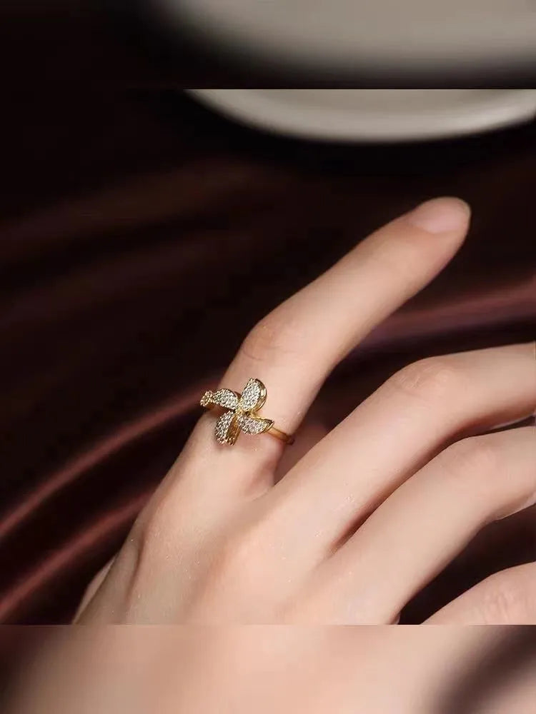 Rotating geometric windmill ring in gold or silver finish on a copper band.