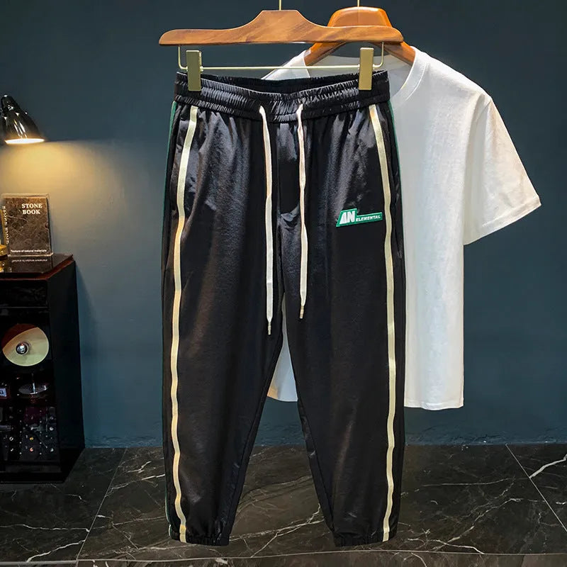 Men's black ice silk harem pants with elastic waistband and tapered leg design