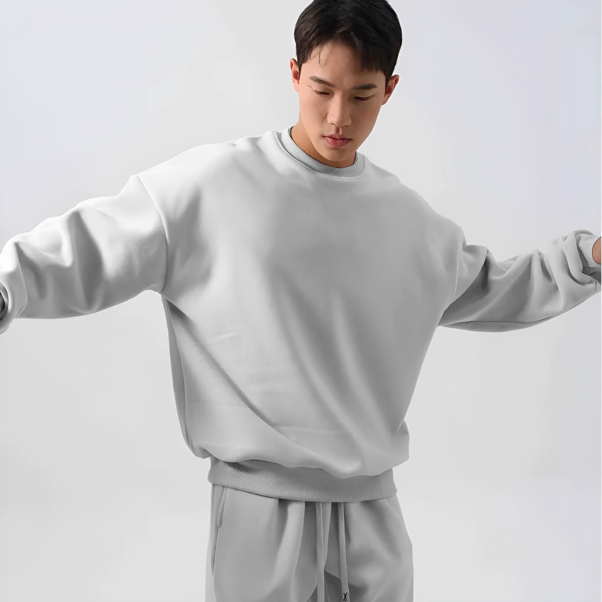 Men's black polar fleece sports suit with crew neck coat and matching trousers on a hanger.