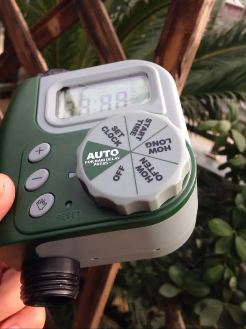 Green digital garden hose timer with large display and dial for automatic sprinkler programming