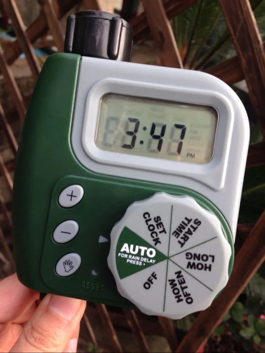 Green digital garden hose timer with large display and dial for automatic sprinkler programming
