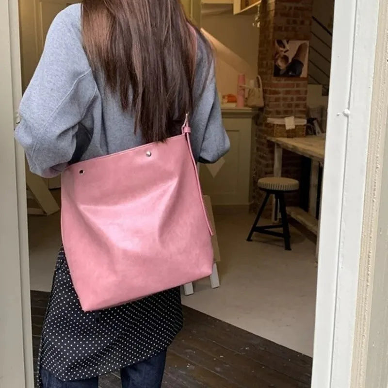 Corduroy one-shoulder commuter bag in pink colour showing textured fabric and structured shape