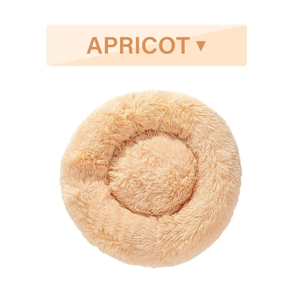 Fluffy donut-shaped dog bed in long plush material, showing raised rim and central cushion.