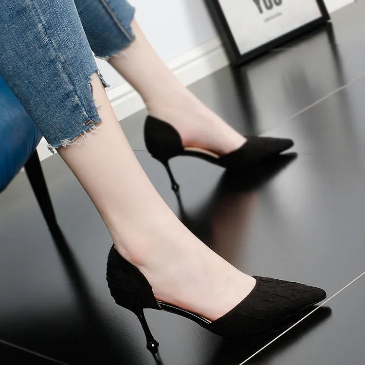 Women's black pointed toe stiletto high heels with a stiletto heel on a plain background.