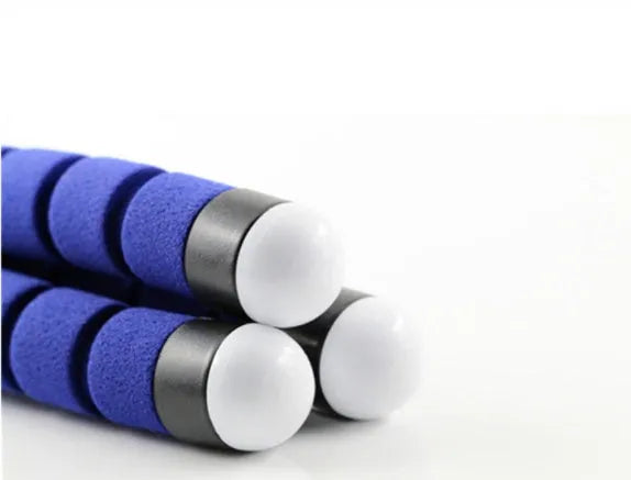 Black flexible octopus tripod with bent legs holding a smartphone on a table.