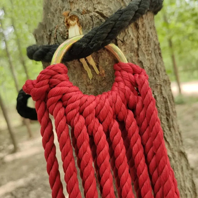 Nylon rope mesh hammock hung outdoors, showing its woven design and included tying ropes.