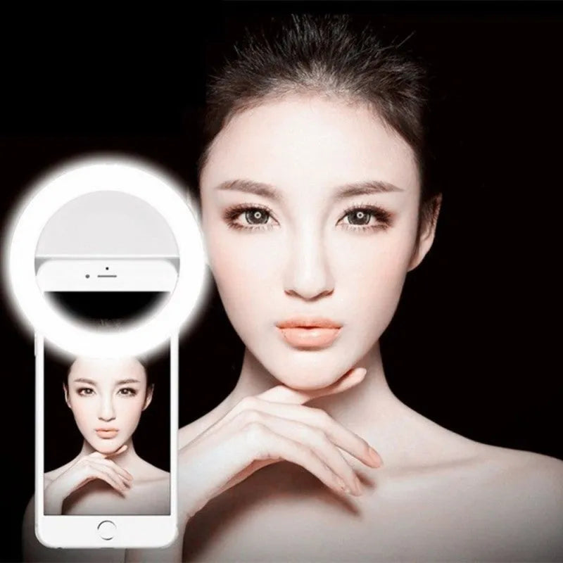 Clip-on LED selfie ring light attached to a mobile phone for low-light photography.