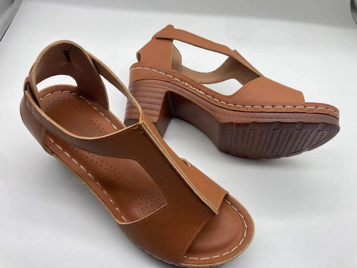 Women's peep toe wedge sandals with Roman-style buckle on a low heel.